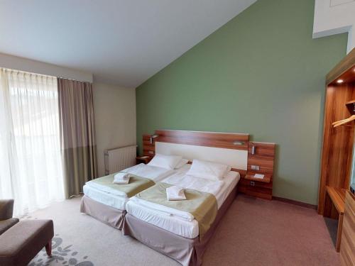 a hotel room with two beds and a large window at Mercure Tagungs- & Landhotel Krefeld in Krefeld