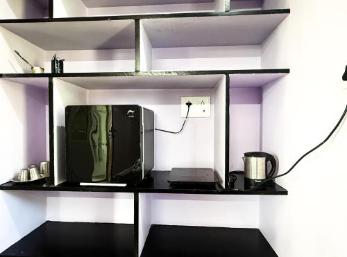 a tv sitting on a shelf in a room at NAKSHATHRA Guest House 2BHK in Tiruvannāmalai