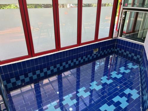 a swimming pool with blue tiles in a building at Gapyeong The Haru Emotional Pool Villa in Mŏk-kol