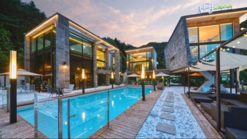 a large building with a swimming pool in front of it at Avec J Pool Villa in Samgŏ-ri