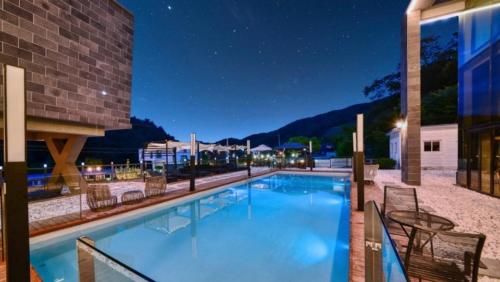 a large swimming pool with chairs and a building at Avec J Pool Villa in Samgŏ-ri