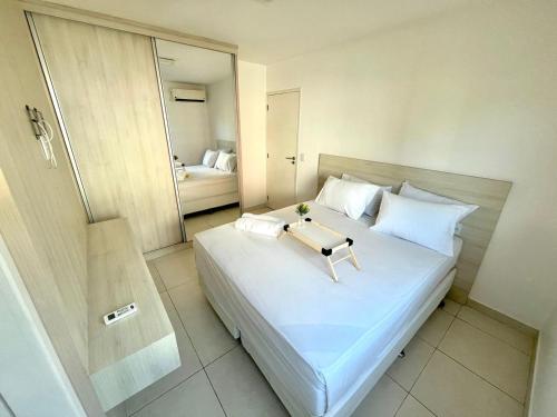 a bedroom with a white bed with a tray on it at Flat espaçoso e confortavel no hotel Canarius Gravata in Gravatá