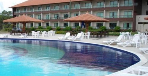 a large swimming pool in front of a hotel at Flat espaçoso e confortavel no hotel Canarius Gravata in Gravatá