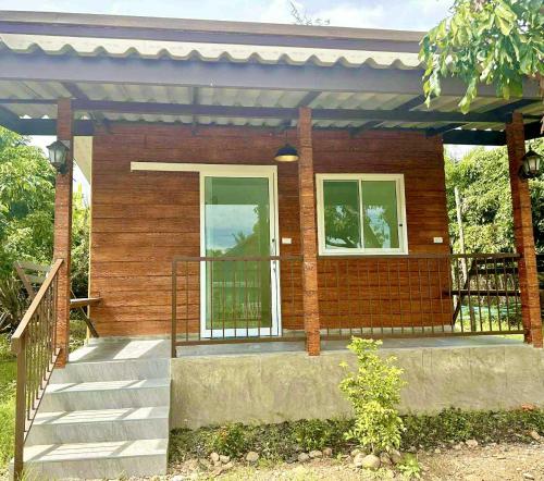 a small house with a staircase and a porch at นาปุย คันทรีโฮม Napui Countryhome 纳普乡村别墅 in Ban Huai Kaet