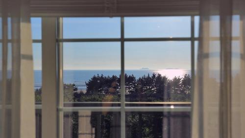 a view of the ocean from a window at Taean Janggong Pension in Yangjimal
