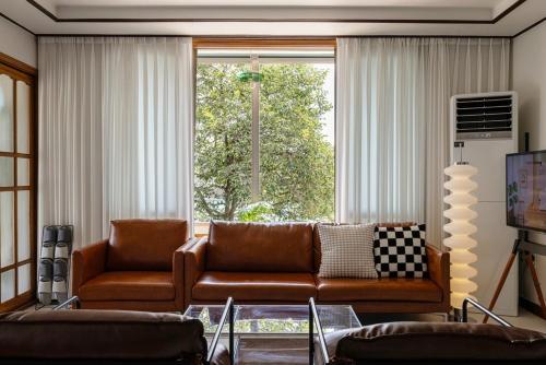 a living room with a couch and a large window at Asan Wolang Stay in Asan