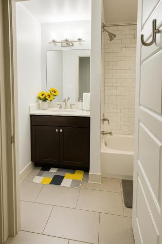 a bathroom with a sink and a tub and a mirror at Drop Your Bags In Your 2 Bdrm, 2 Full Bath Condo In French Quarters Prime Location in New Orleans