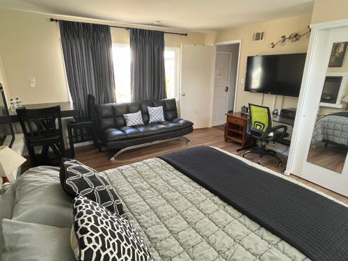a bedroom with a bed and a couch and a television at 2 Bedroom House OR Private Studio near SF, SFSU and SFO in Daly City