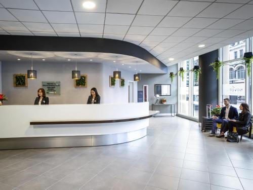a lobby with people sitting at a reception desk at Novotel Reading Centre in Reading
