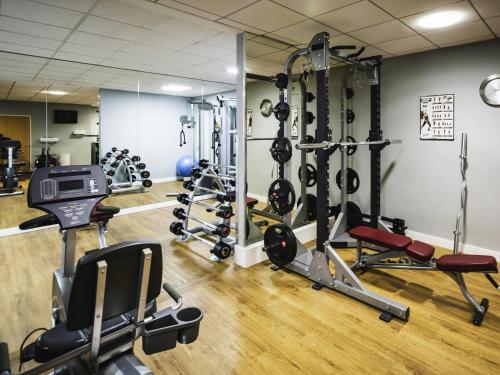 a gym with several treadmills and weights at Novotel Reading Centre in Reading