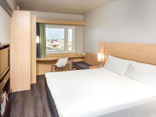 a hotel room with a bed and a window at ibis Aracaju in Aracaju