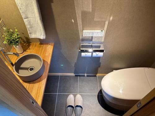 a bathroom with a toilet and a sink at 椿とことは in Obama
