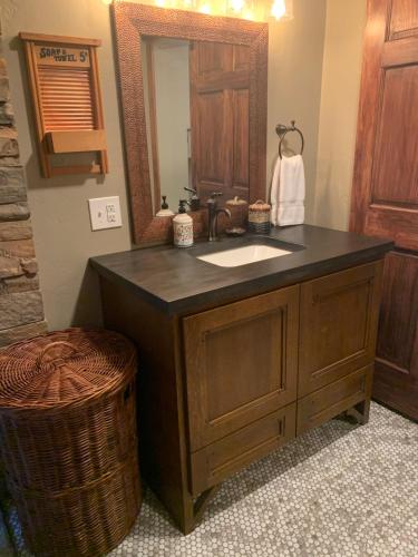 a bathroom with a sink and a mirror at Cozy 3-Bedroom Grand Chalet in Delta