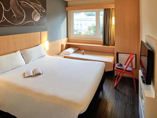 Una cama o camas en una habitación de ibis Curitiba Batel