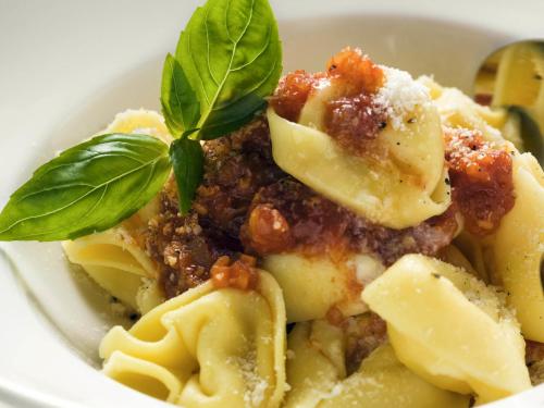 a bowl of pasta with a basil leaf on top at ibis Betim in Betim