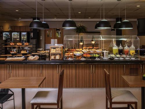 a restaurant with a counter full of food at ibis Betim in Betim