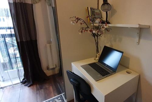 a laptop computer sitting on a desk in a room at Lovely Room with a view & Parking nr Hampton Court in West Molesey