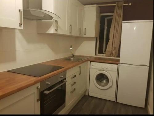 a kitchen with a sink and a washing machine at Lovely Room with a view & Parking nr Hampton Court in West Molesey