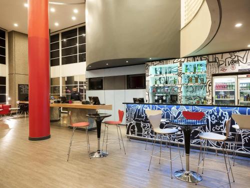 a restaurant with chairs and a bar with graffiti at ibis Campinas in Campinas