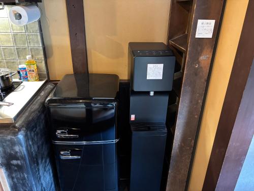 a trash can and two trash cans in a kitchen at 椿とことは in Obama
