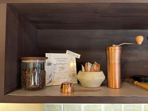 a shelf with a jar of nuts and a book at 椿とことは in Obama