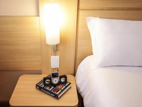 a bed with a night stand with a radio on it at ibis Sao Paulo Interlagos in Sao Paulo