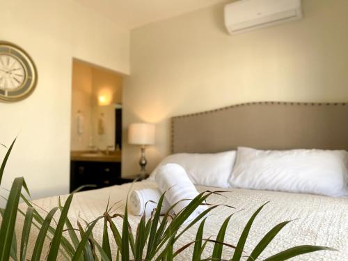 a bedroom with a bed with a clock on the wall at Casa Atardecer con Alberca en Privada, 5 min del Aeropuerto y Consulado Americano in Hermosillo