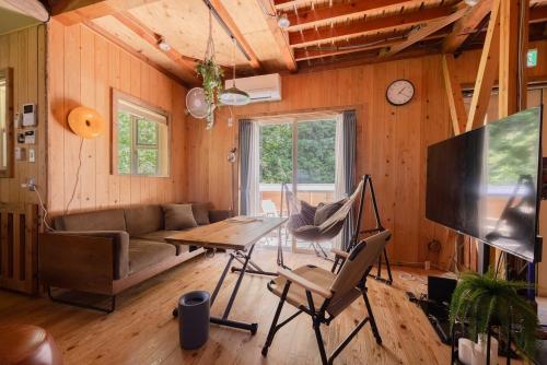 a living room with a couch and a table at 葉山ヒュッゲ in Hayama