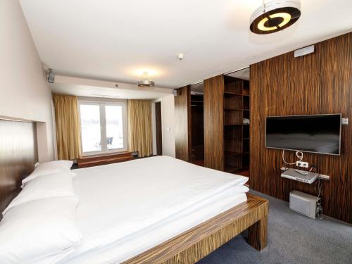a bedroom with a large bed and a flat screen tv at Ibis Praha Old Town in Prague