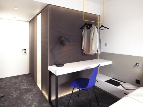 a room with a white desk and a blue chair at Ibis Praha Old Town in Prague
