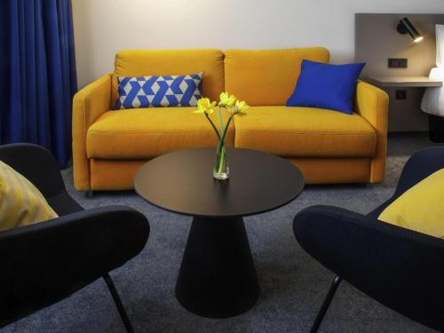 a living room with a couch and a table with flowers at Ibis Praha Old Town in Prague
