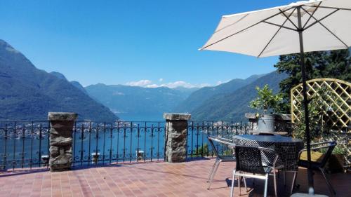 a patio with a table and an umbrella at Sweet Home in Faggeto Lario 