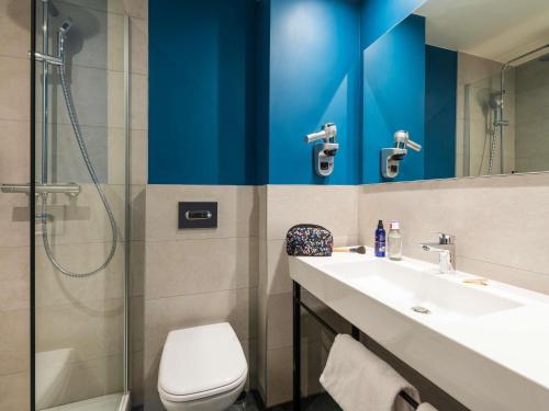 a bathroom with a toilet and a sink and a shower at ibis Nuits Saint Georges in Nuits-Saint-Georges