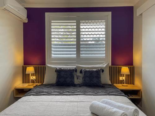 a bedroom with a large bed with a window at Quarterdeck Apartments in Gladstone