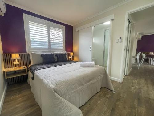 a bedroom with a large bed and a window at Quarterdeck Apartments in Gladstone