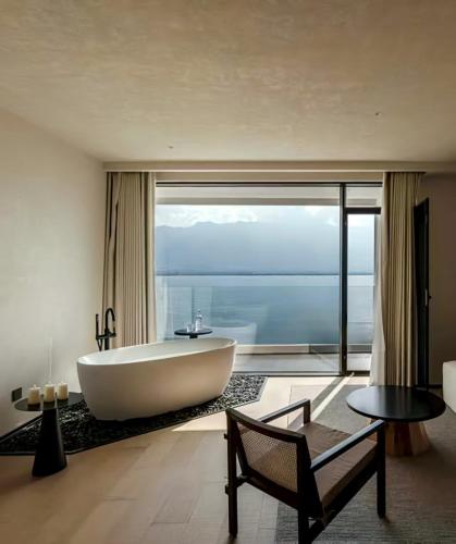 a bath tub in a bathroom with a large window at YS Seaview Hotel in Dali
