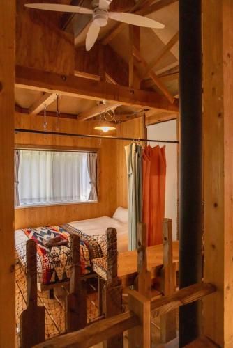 a bedroom with a bed and a ceiling fan at 葉山ヒュッゲ in Hayama