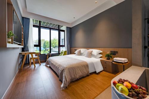 a bedroom with a bed and a bowl of fruit at Floral Hotel Hangzhou Fuju Holiday Manor 
