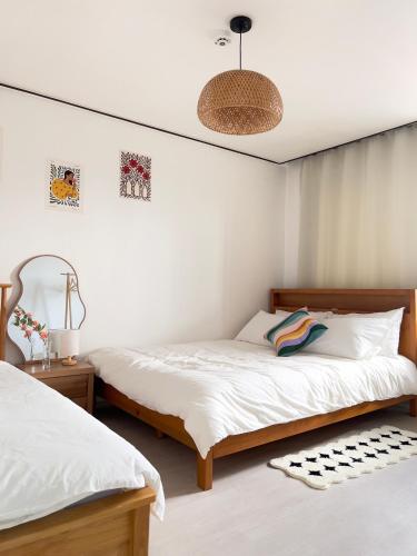 two beds in a room with white walls at Open Special #Guro Station 5 minutes on foot #Hongdae and Gangnam Subway Direct #Gocheok Dome #7-person family and group accommodation in Seoul