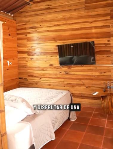 a room with a bed in a wooden wall at Cabañas Viva Mexico in Ibagué