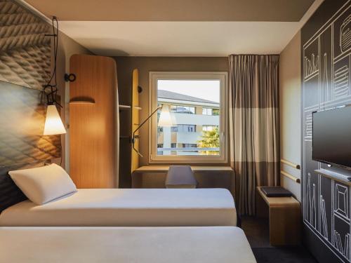 a hotel room with two beds and a window at ibis La Ciotat in La Ciotat