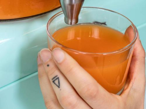 a hand holding a glass of orange juice at ibis La Ciotat in La Ciotat