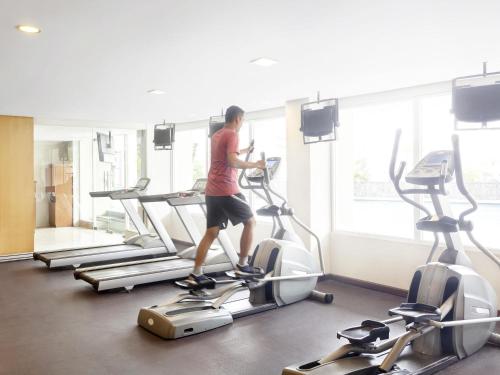 a man walking on a treadmill in a gym at Novotel Semarang in Semarang