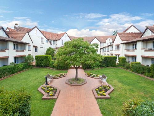 a courtyard with a tree in the middle of a yard at Mercure Canberra in Canberra