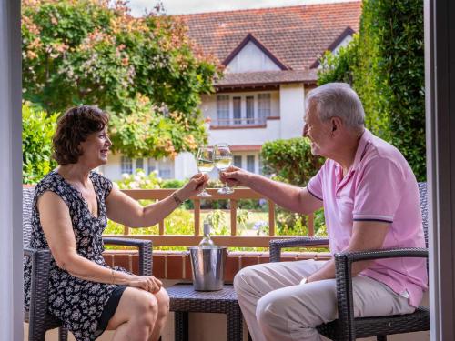 a man and woman sitting at a table drinking wine at Mercure Canberra in Canberra