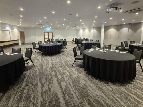 a large room with tables and chairs in it at Mercure Canberra in Canberra