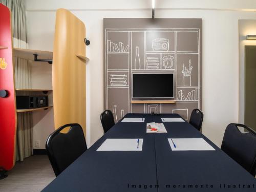 a conference room with a table and a tv at ibis Sao Paulo Morumbi in Sao Paulo