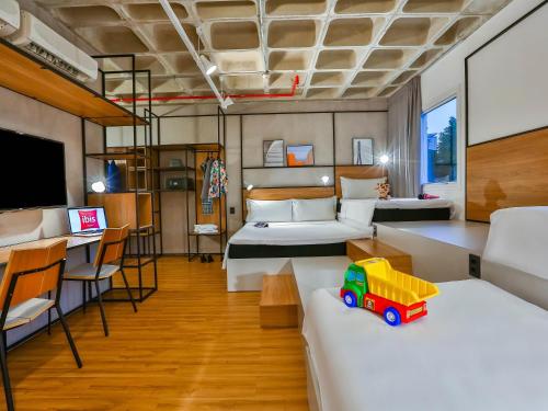 a room with two beds and a toy train on a table at ibis Sao Paulo Morumbi in Sao Paulo