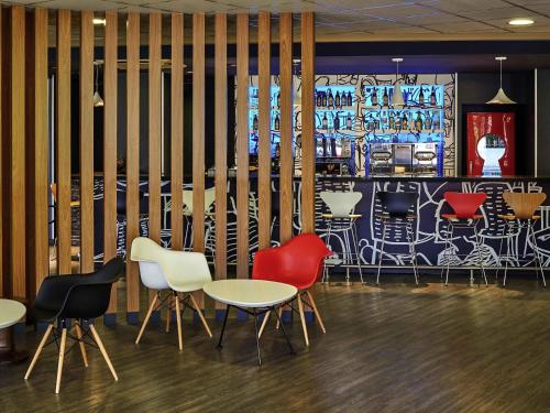 a restaurant with tables and chairs and a mural at ibis Sao Paulo Morumbi in Sao Paulo