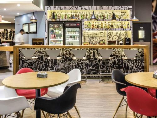 a restaurant with tables and chairs and a bar at ibis Araçatuba in Araçatuba